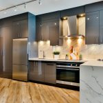 Moderne keuken onderhouden met glanzende kasten, marmeren achterwand en goed geventileerde kookruimte