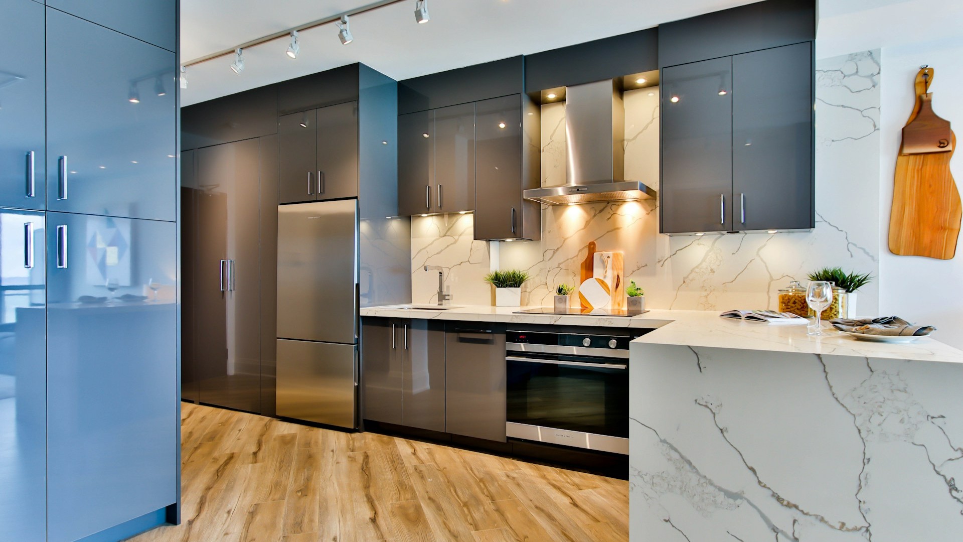 Moderne keuken onderhouden met glanzende kasten, marmeren achterwand en goed geventileerde kookruimte