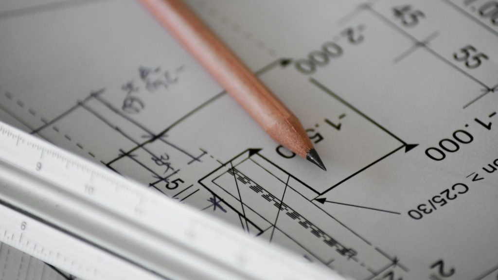 Potlood en liniaal op technische bouwtekening van een nieuwbouwproject met maatvoering en schetslijnen