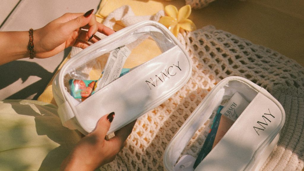 Gepersonaliseerde toilettassen met namen Nancy en Amy die open liggen met verzorgingsproducten