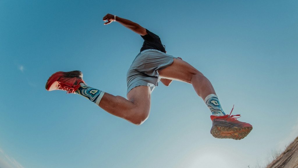 Hardloopschoenen met dikke zool tijdens sprong, gericht op demping en energieteruggave