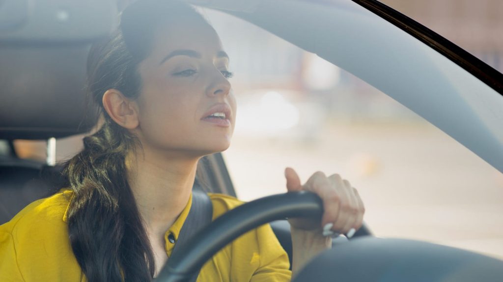 Vrouw achter het stuur tijdens rit in automaat of handgeschakeld auto