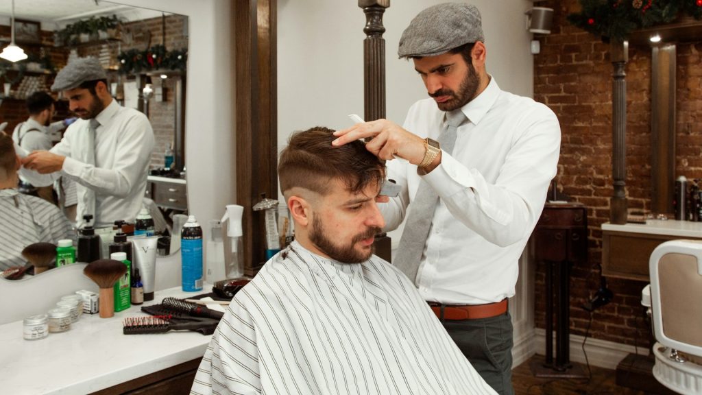 Barbier knipt haar en stemt kapsel af op gezichtsvorm kapsel voor een gebalanceerde uitstraling