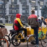 Mensen op die fiets die moeten wachten voor een stoplicht
